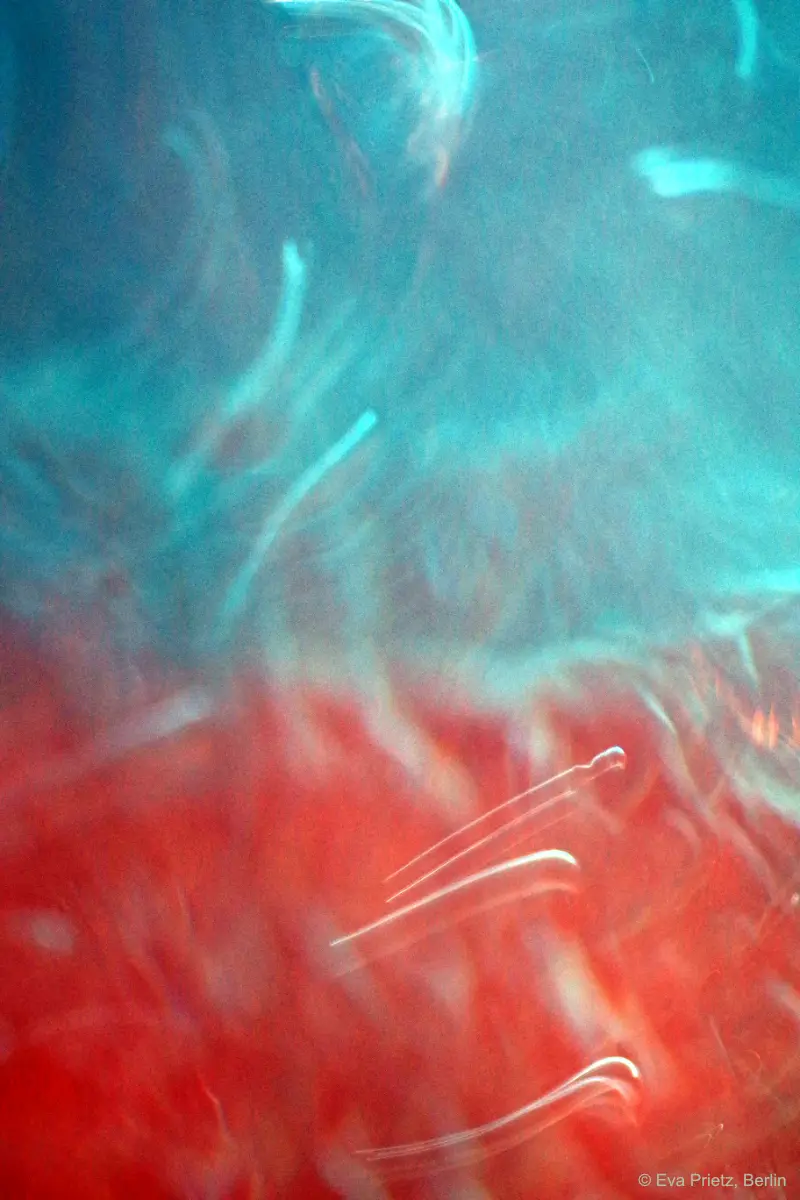 Abstrakte Wasserbewegung in Rot und Blau als Sinnbild für Entwicklung, Klarheit und Orientierung in der Führungskräfteentwicklung und im Coaching